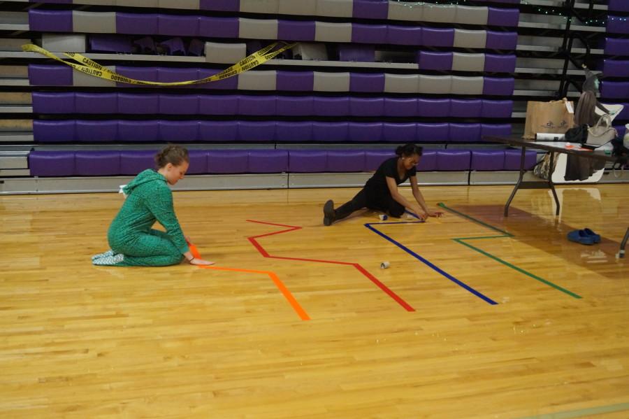 Senior Lauren Klapper and senior Sydney Spears put tape down to create a makeshift maze. Although it took awhile to set up, they got their first “trick or treater” within minutes of the doors opening to the gym for the annual Pumpkin Patch.