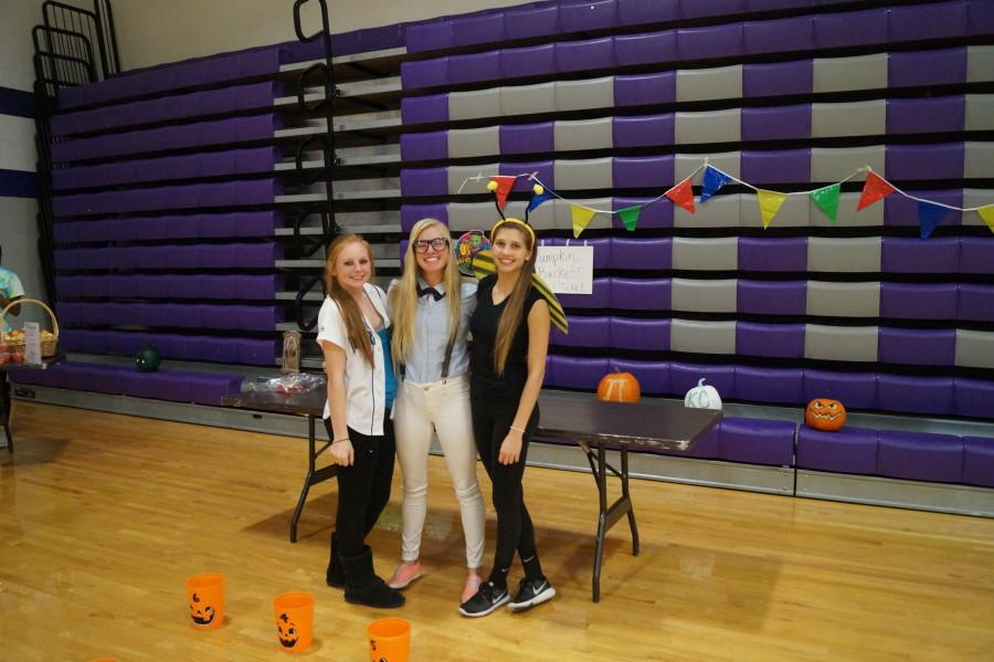 Freshman Alison Henry, sophomore Makayla Stack and freshman Shelby Rome work together to work the bucket toss station. The excitement on the children’s faces after making one ball in a bucket was priceless. 