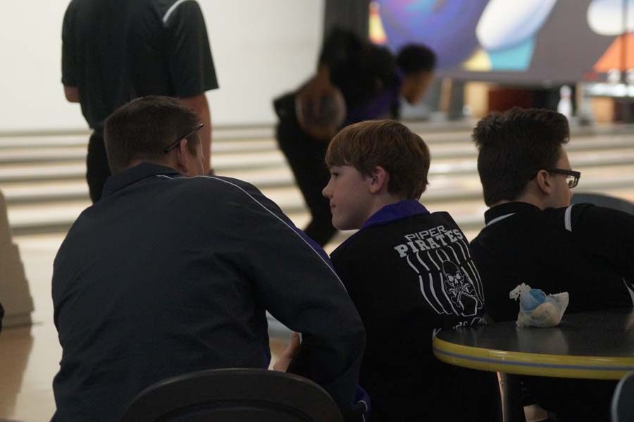 Coach Gray sits beside freshman Logan Vogel to talk about his game and give him a few notes for his next time up to bowl.