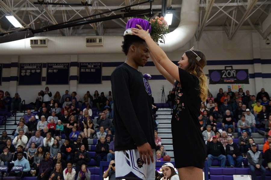Senior Daviance Covington, and varsity basketball player accept his crown from Bel Wilcoxen since former king Brian Rodgers could not make it back for the celebration.