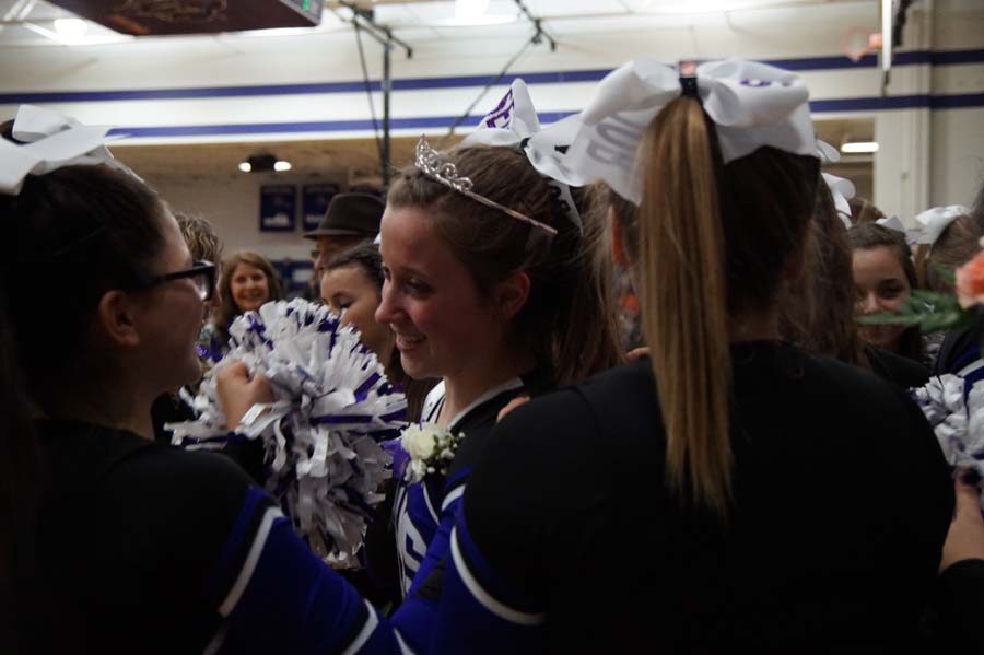 Senior Sophia Frick is surrounded by the cheerleading team as they all cheer with her in the game and for her when she won courtwarming queen.