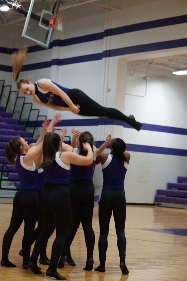 Sophomore Morgan Haworth twists in the air as her teammates prepare to catch her. 