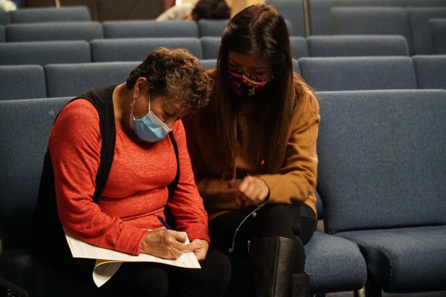 Spanish interpreter assists community member in understanding the survey given before the screening process begins. 